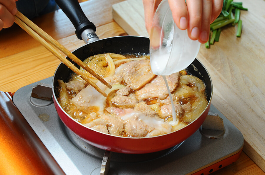 肉に火が通ったら、水溶き片栗粉でとろみをつけて、ニラを加えます。
