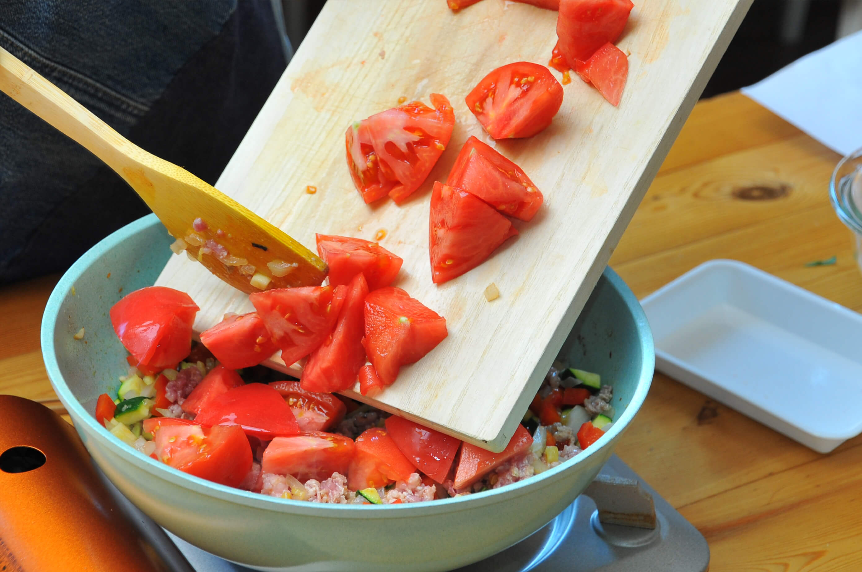 野菜がしんなりしてきたら、ひき肉を加えて炒めます。ひき肉の色が変わって来たら、トマト、水を加えて煮込みます。