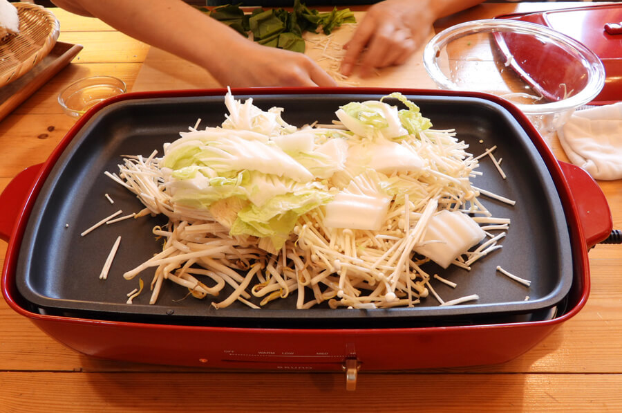 ホットプレートにオリーブオイルを入れて、もやし、白菜、えのきを敷き詰めます。