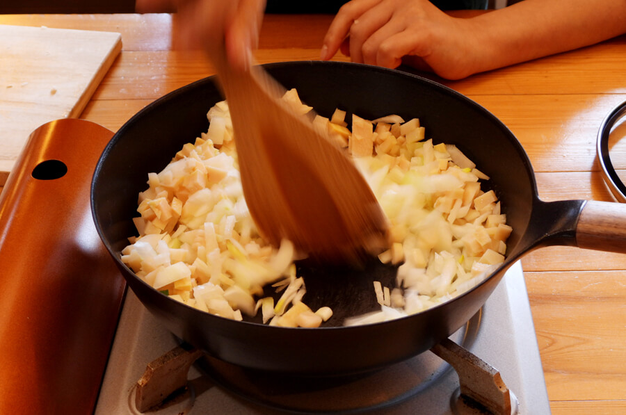 フライパン（またはホットプレート）にバターを入れて、たまねぎ、筍を炒めます。