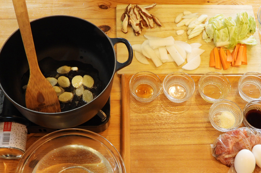 鍋にごま油、ニンニクを入れて火にかけます。ニンニクのいい香りがしてきたら、大根、にんじん、塩小さじ２分の１を入れて炒めます。