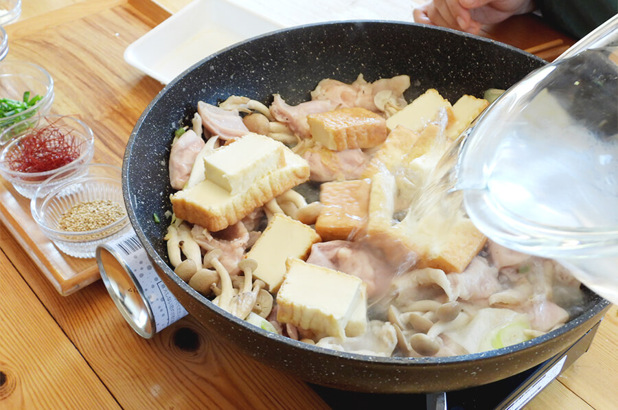 しめじがしんなりしてきたら、水、鶏がらスープ、豆腐を入れて煮ます。