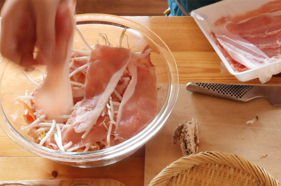 耐熱ボウルに、もやし、肉。しめじ、にんじん、酒、塩を入れて肉同士がくっつかないようにまぜあわせます。